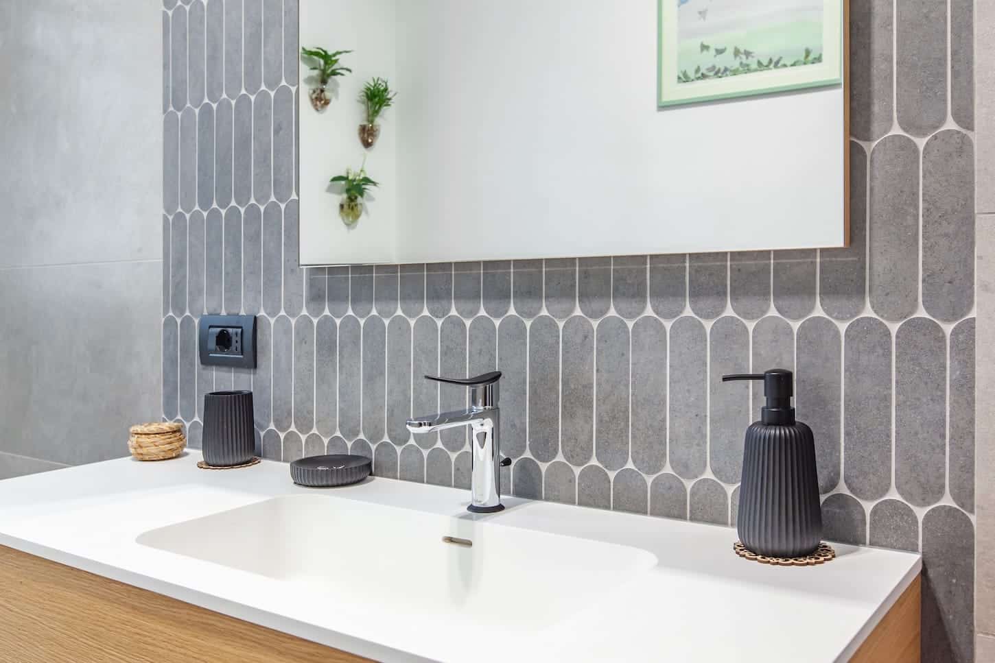 Dettaglio di bagno contemporaneo con superfici coordinate e poche interruzioni visive