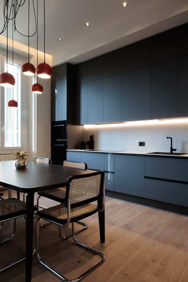 Cucina con parquet in legno chiaro, open space su soggiorno, progetto Creo Casa Milano